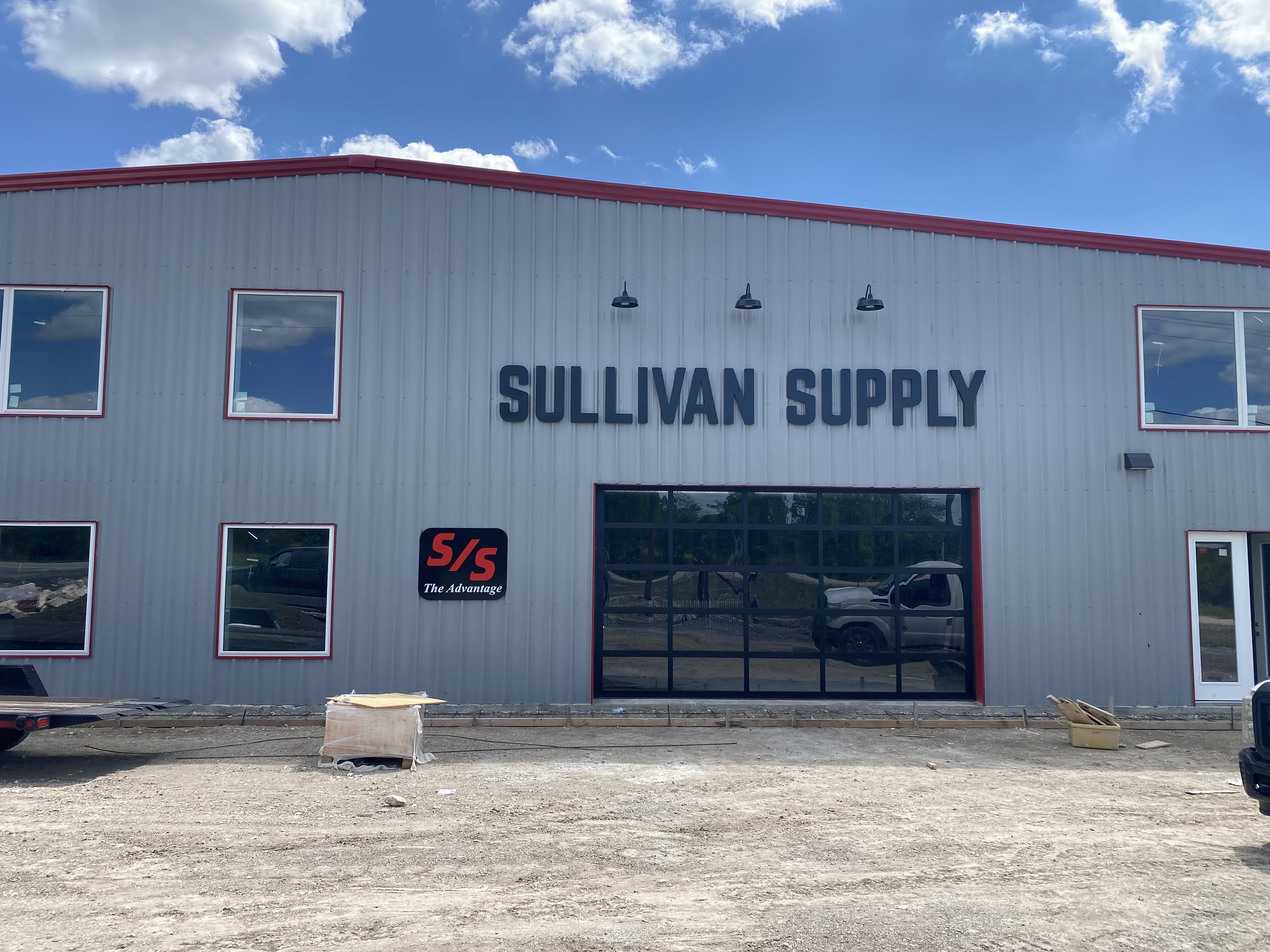 Large full-view glass commercial overhead door installed at Sullivan Supply commercial building