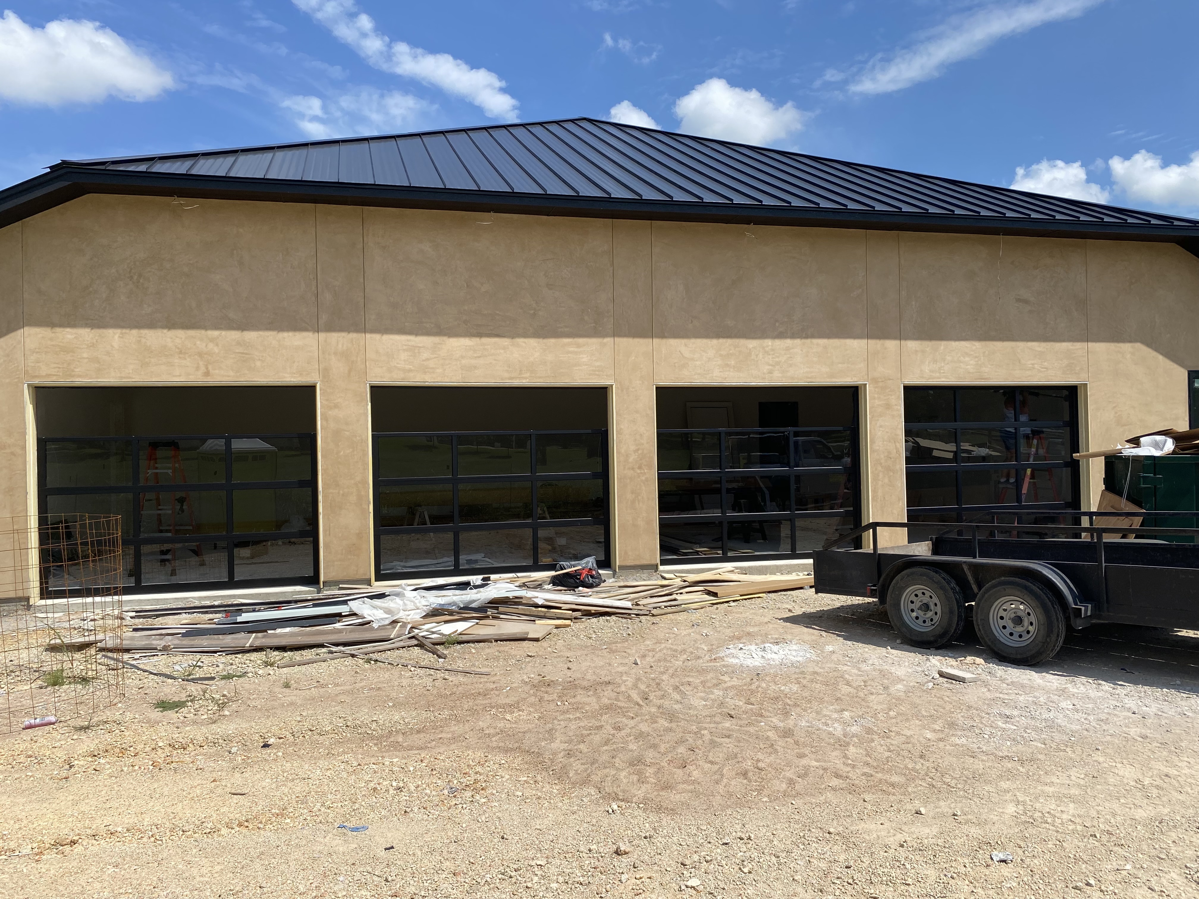 Four full-view glass commercial overhead doors installed on new construction building in Central Texas