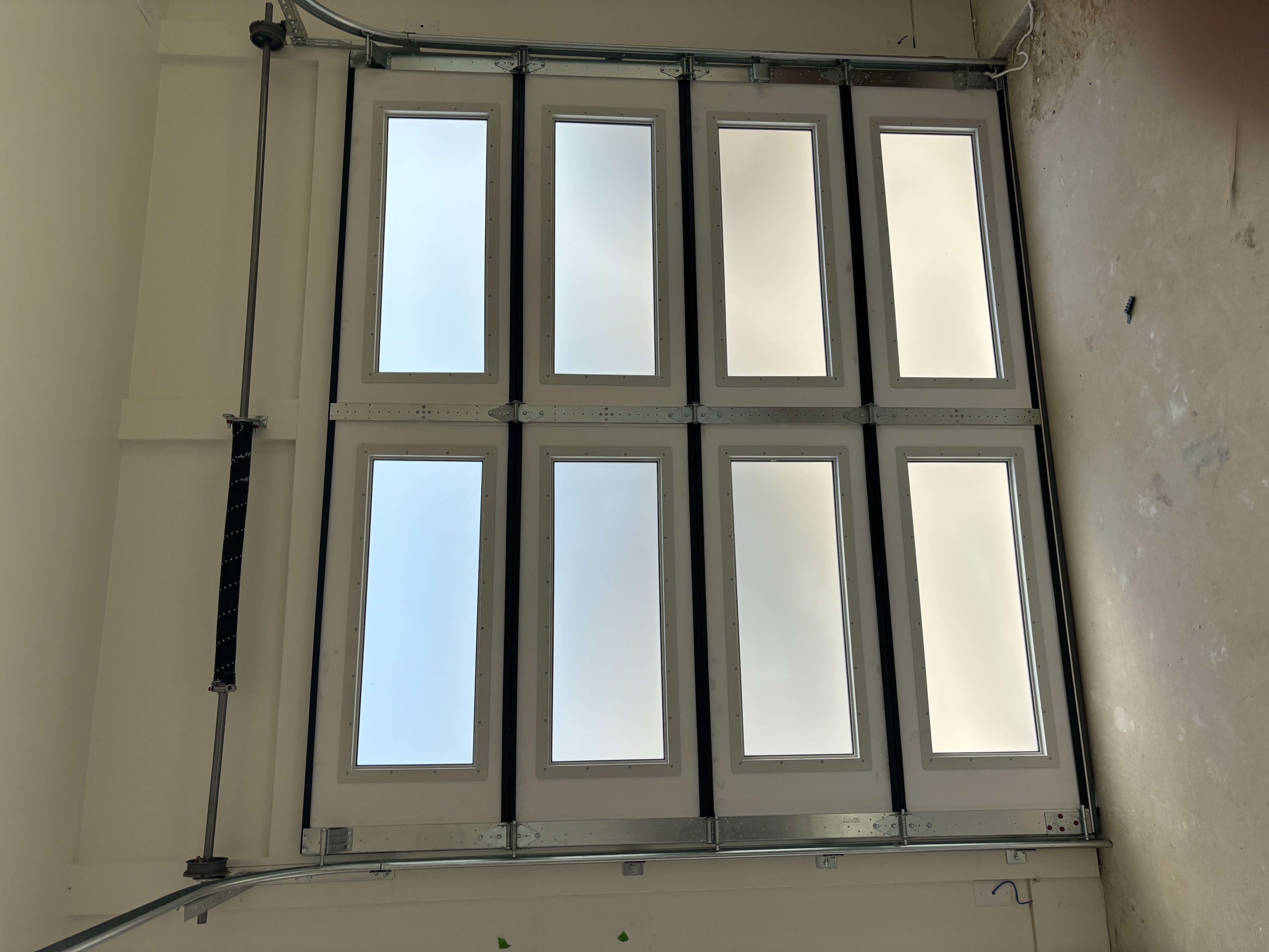 Interior view of modern white aluminum garage door with large horizontal windows, newly installed